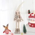 Detail of Christmas gnome plush featuring retractable striped legs and Merry banner - Medium Girl
