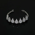 Primer plano de pulsera nupcial plateada con cristales de gota sobre superficie negra brillante - Pulsera de Circonita Blanca