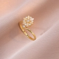 Detailed macro view of a golden flower ring with light gemstones on pink fabric - Cat Eye Stone Rotating Ring (J0353)