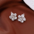 Macro shot of silver flower earrings with clear zircon stones on dark velvet - Ear Buckle / White