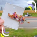 Detail view of cat-shaped acetate hair clip with marble texture on display card - Bright Floral
