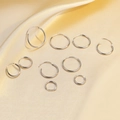 Minimalist S925 sterling silver hoop earrings set displayed on champagne silk fabric - White Gold