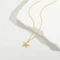 Gold plated starfish pendant necklace on a textured white stone surface in a minimalist style - Starfish (XL3336-1)