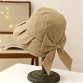 Beiger Sonnenhut mit breiter Krempe und großer Schleife auf Holzständer mit warmem Licht - M (56-58cm) / Khaki