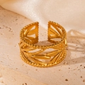 Close-up of 18K gold plated hollow leaf pattern open ring on textured stone - Leaf Gold 83