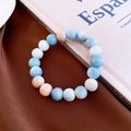 Detail of beaded bracelet with blue and cream marble texture on a dark silk fabric - Blue White Orange-Marble Pattern