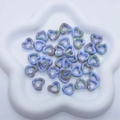 Detail of blue and green ink marble ceramic heart beads in a white star tray for DIY jewelry - Blue & Green Swirl