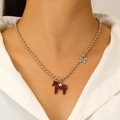 Primo piano dei ciondoli pony in smalto rosso e stella dorata su collana a sfere - Rosso Giuggiola (A-650)