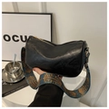 Detail of soft black leather bag featuring a wide blue and gold peacock pattern strap - Black