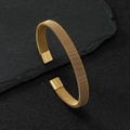Bracciale aperto in maglia d'acciaio inossidabile dorato su una superficie di roccia nera - 8mm / Oro