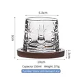 Rotating spinning whiskey glass with face relief design and brown wooden base - Face Pattern Tumbler Glass With Wood Base