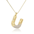 Detailed close-up of a gold letter U pendant with shimmering white cubic zirconia accents - Letter U