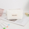 Close-up of white plush cosmetic bag with waffle texture and meyou fairy woven label - White