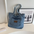 Borsa tote in denim lavato blu con toppa logo in pelle goffrata su sfondo bianco - Azzurro