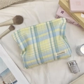 Close-up of yellow and light blue checkered cotton makeup bag with brand logo label - Blue