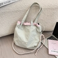 Détail du sac cabas en nylon vert clair avec cordon rose et bandoulière tissée - Gris clair