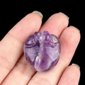 Purple natural amethyst cat paw carving held in hand for size visualization - Amethyst