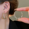 Close-up of minimalist irregular twisted silver earrings worn by a female model - Silver Irregular Hoop Style (110#)