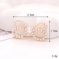 Détail macro d'un accessoire nœud en perles blanches mesurant 3,5 cm sur 1,9 cm - D2484-35mm*19mm Nœud Ajouré