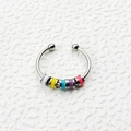 Detalle de anillo giratorio plateado con cinco cuentas de esmalte de colores sobre fondo - Blanco Amarillo Verde Púrpura Rosa