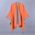 Detail view of a double-sided knitted poncho showing vibrant orange and light brown grey fabric - Orange Brown Patchwork