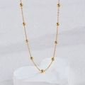 Minimalist gold beaded necklace set on heart-shaped display with a polished metallic finish - Gold - Simple Beaded Necklace