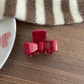 Elegant red bow hair claw clip with gold Barrette La France text on wood background - Red