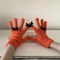 Close-up of orange knitted touchscreen gloves with cute black bow detail decorations - One Size / Orange