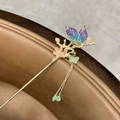 Primer plano de una horquilla dorada vintage con flores de durazno y mariposas - Horquilla de Flor de Mariposa Colorida