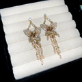 Detailed macro view of butterfly tassel earrings with sparkling crystals on a white display - S925 Silver Pin/Alloy/Zircon/Crystal / Gold-Pink