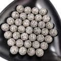 Polished grey spotted quartz crystal stone spheres arranged in a black triangular bowl - 25mm No Hole Sphere / Granite