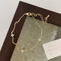 Detail of gold chain bracelet with three clover charms and shimmering crystal inlays - Clover Bracelet / Gold White