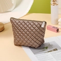 Brown quilted cosmetic bag with rhombus pattern on magazine in a cozy setting - Trapezoid Bag / Brown