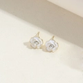 Macro shot of white camellia stud earrings with gold edges and diamond-like centers - White Flower