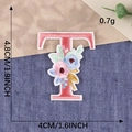 Pink embroidered letter T patch with floral patterns and iron-on backing for clothing - Letter T / Hot Melt Adhesive