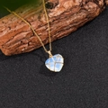 Detalle del colgante de corazón de ópalo envuelto en hilo dorado sobre base de madera - Con Cadena / Ópalo