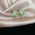 Detailaufnahme der Vintage Emaille Ohrringe mit Perlen auf weichem Champagner Seidenhintergrund - 32# Emaille-Perlen-Vintage-Stil / Gold Grün Violett