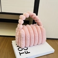 Borsa in peluche rosa con manico di perle e trama a bolle su un libro bianco - Rosa
