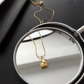 Creative close-up of gold heart pendant necklace reflecting on a circular mirror - 01-K23 Titanium Steel Heart Necklace Gold