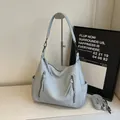Borsa tote celeste a tracolla con texture martellata e dettagli in nappine - Blu