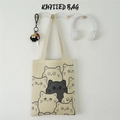 Detailansicht einer beigen Stricktasche mit schwarzem Cartoon-Katzenmuster am Haken - Beiger Katzenwald
