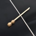Close-up of golden metal hair clip featuring textured shell ornaments on a dark surface - Two Small Shell Bobby Pins / Gold