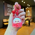 Detail of red liquid shaker keychain with white sheep figure, stars, and small bell - Red Night Light Bubble Beads