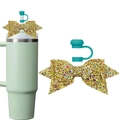Detail of glitter bow and silicone straw cover accessories on a pastel green tumbler cup - Green