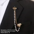 Détail d'une broche baroque à pompons avec étoiles et cœur sur le revers d'un costume - Style Pentagramme et Planète (TL24027)