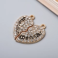 Close-up of golden heart pendants with rhinestones engraved with Mother and Daughter - Gold