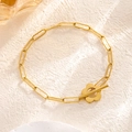 Minimalist gold paperclip chain bracelet with a floral toggle clasp on a stone background - 7863 Flower Bracelet