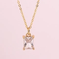 Elegant gold necklace featuring a rectangular transparent gemstone pendant on pink background - White