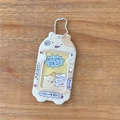 Detailansicht eines süßen Hamster-Kartenhalters mit weißer Kugelkette auf einem Holztisch - Gelber Hamster