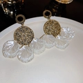 Detaillierte Makroansicht der Vintage Goldohrringe mit perlweißen Quastenblättern - Silbernadel / Goldener runder Muscheltropfen